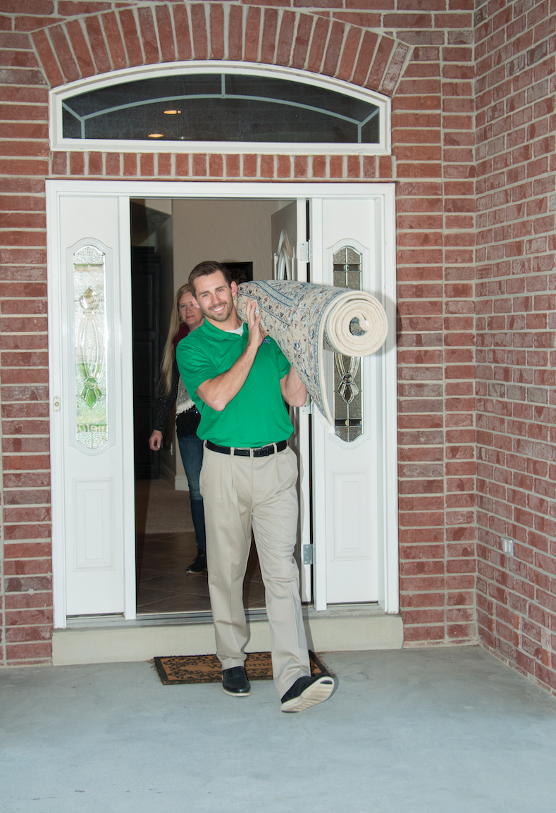 Chem-Dry technician collecting rug for cleaning